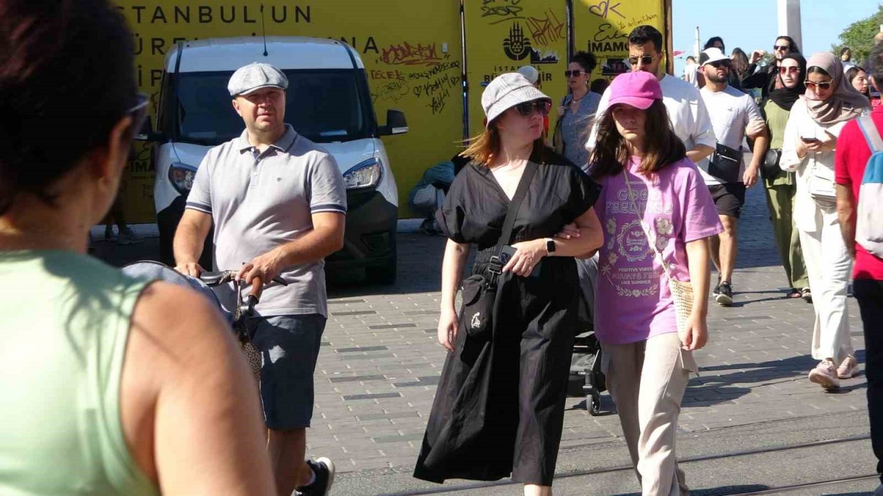 Taksim’de sıcaktan bunalan vatandaşlar şemsiye ile gezdi