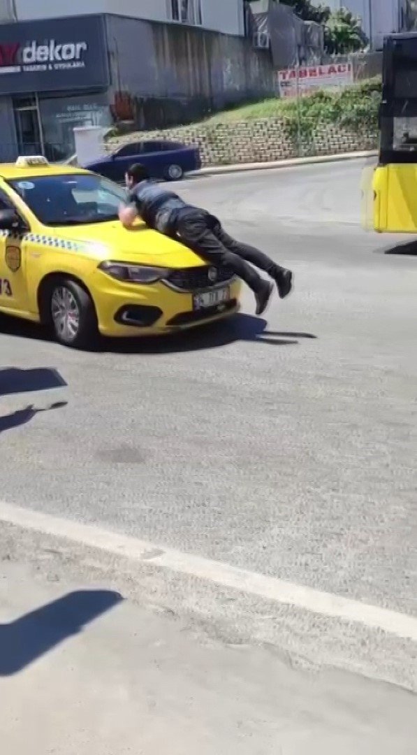 Pendik’te taksinin kaputuna çıkıp camı patlattı