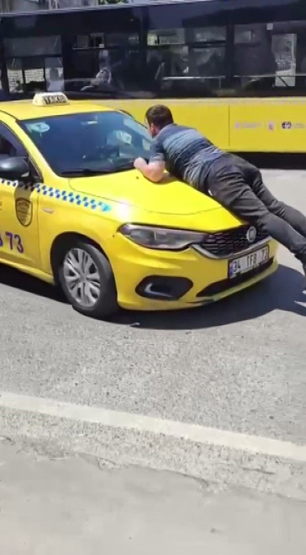 Pendik’te taksinin kaputuna çıkıp camı patlattı