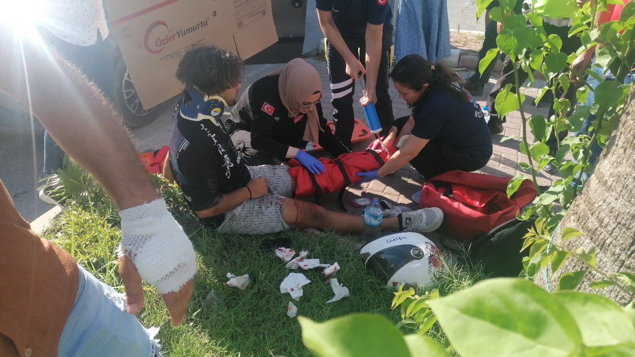 Yerde acı içerisindeki yaralıyı yakıcı güneşten kartonla korudular