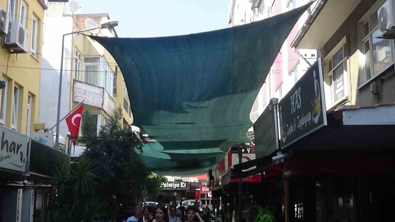 Aşırı sıcaklardan bunalan esnaf, gölge olsun diye sokağın üstünü zeytin brandaları ile örttü
