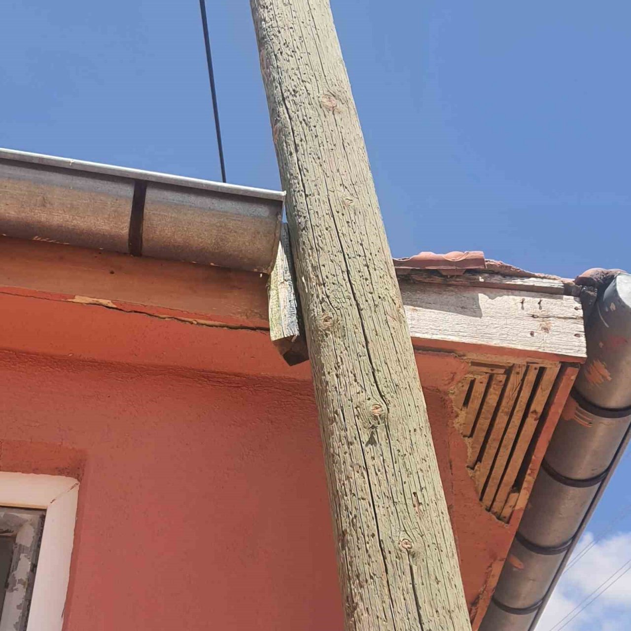 Yan yatan haberleşme direği iki katlı evin çatısına zarar verdi