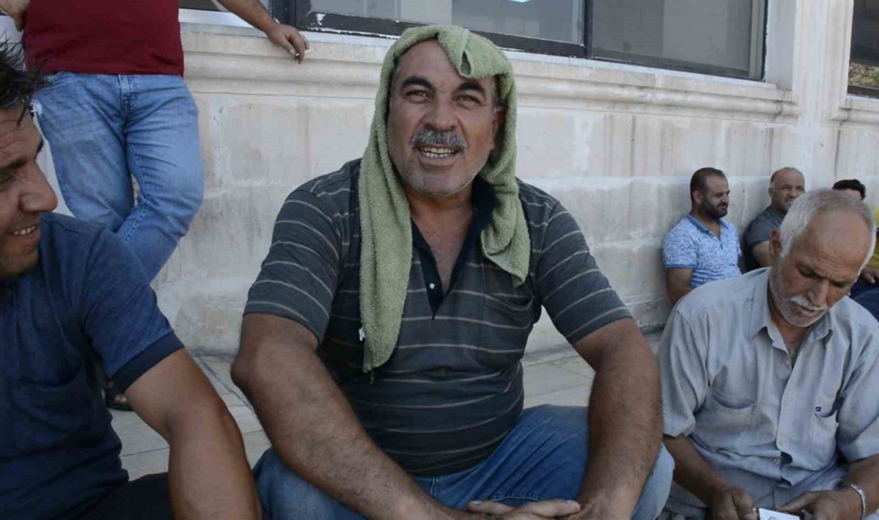 Şırnak’ta tır parkında bekleyen şoförler araçlarının gölgesinde serinliyor