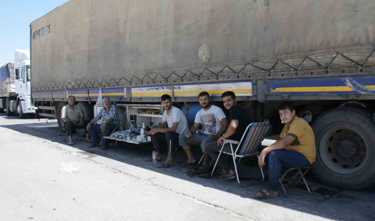 Şırnak’ta tır parkında bekleyen şoförler araçlarının gölgesinde serinliyor