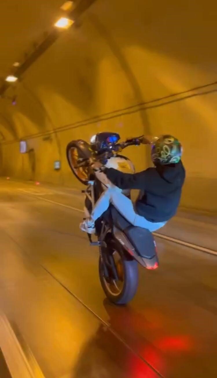 Tünelde motosikletle tek teker giden maganda kamerada