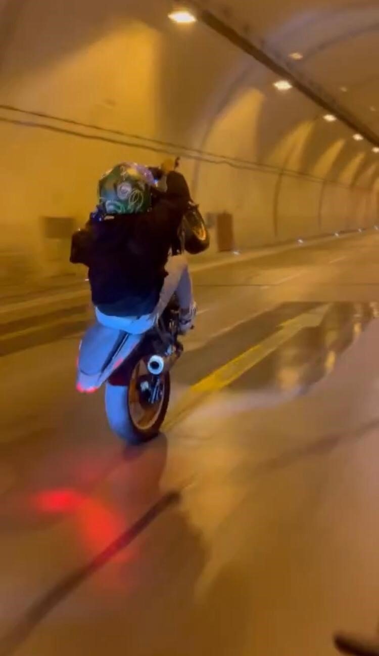 Tünelde motosikletle tek teker giden maganda kamerada