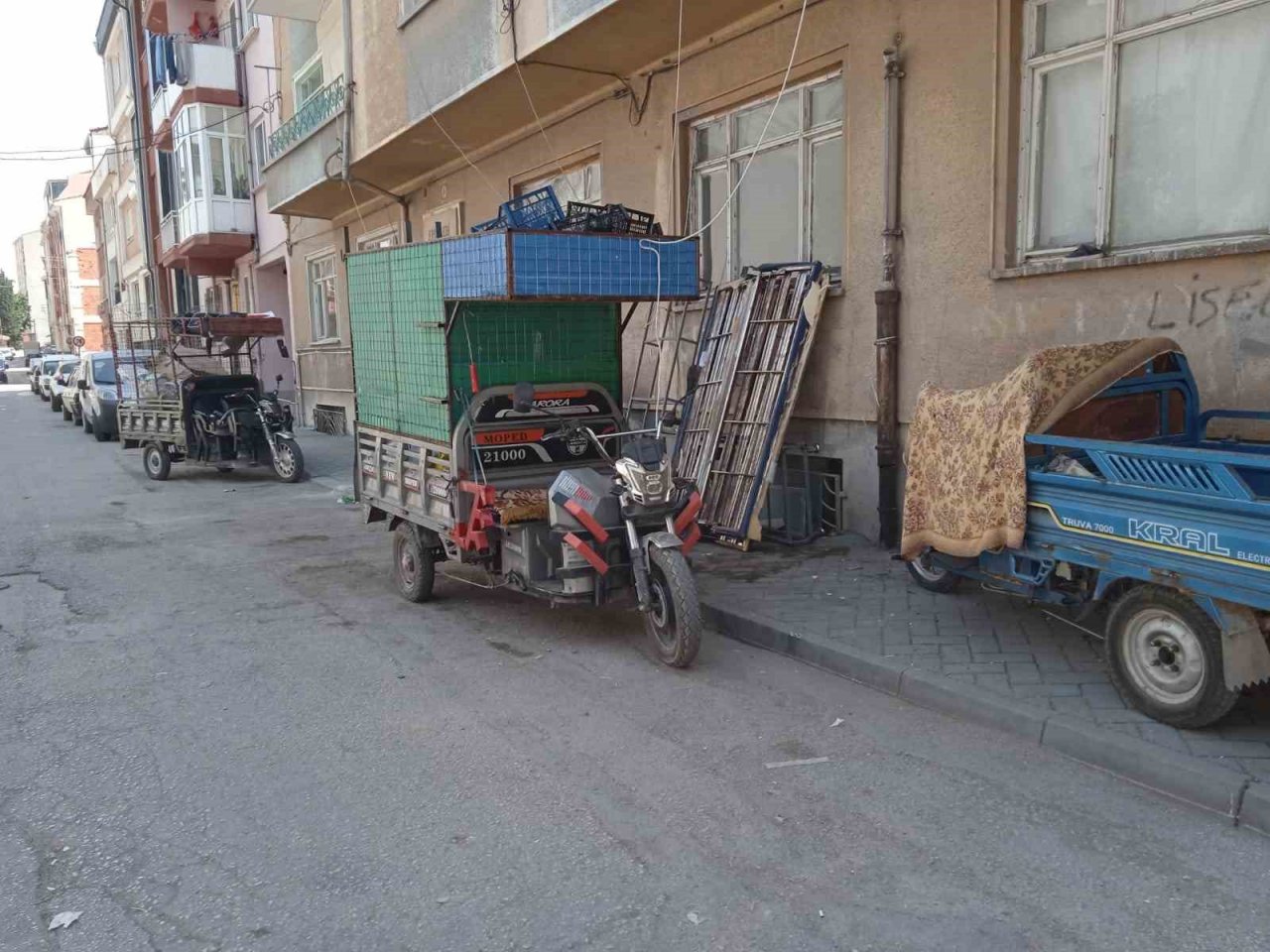 Geri dönüşüm işçilerinin motosikletleri kaldırımdaki engelli rampasını kapatıyor