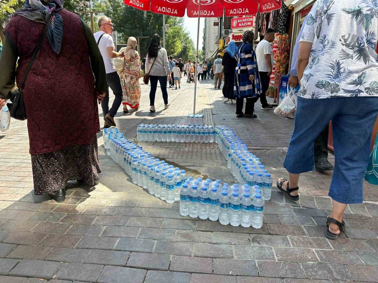 Kaldırımda beton döktüğü alanı su şişeleriyle çevreledi