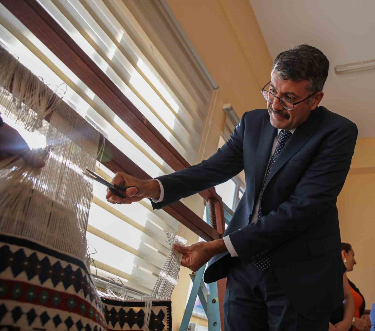 Vali Çelik, kadın kursiyerlerin yerine kilim kesti