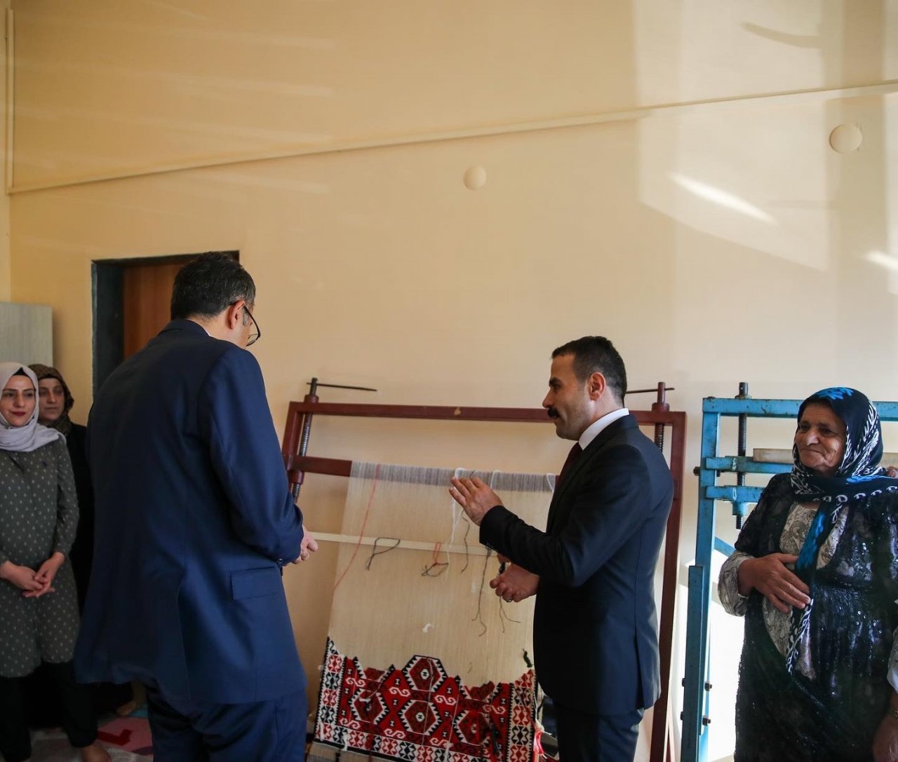 Vali Çelik, kadın kursiyerlerin yerine kilim kesti