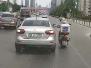 Arızalanan motosikletiyle otomobilin camına tutunup seyahat eden motosikletli kamerada